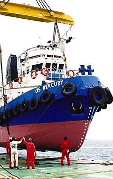 ship being loaded onto a barge with a crane